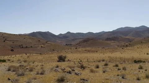 Aerial Drone Shot of dry empty spanish desert with vegetation and mountains in Stock Footage 119356703