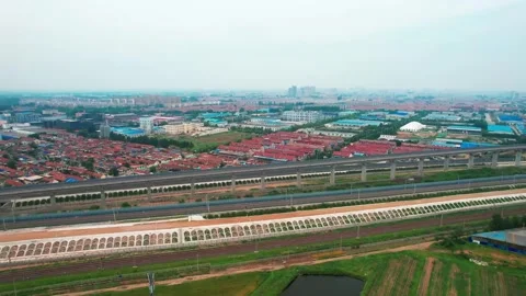 Aerial Drone Shot of Elevated High-Speed Railway Through Suburban Farmland Stock Footage 345818905