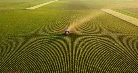Aerial drone shot of a farmer spraying soybean fields Stock Footage