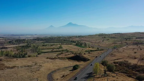 Aerial drone shot of fields and car road on background of Ararat mountains Video stock 124102058