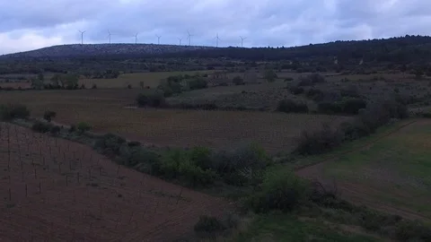 Aerial Drone shot on fields with wind turbines in background during the summer. 스톡 동영상 108620996