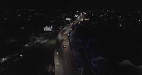 Aerial drone shot : fly over vehicles crossing the bridge in town at night Stock Footage 100580286