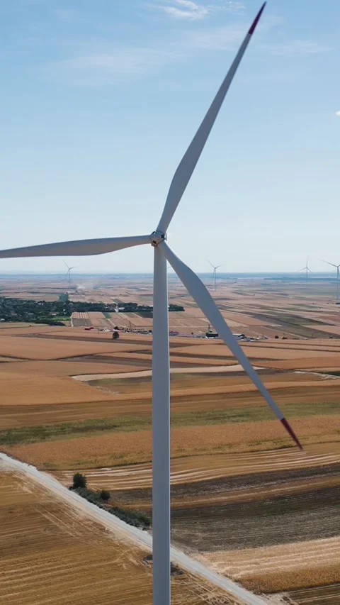 Aerial drone shot flying to the right around a spinning wind turbine in a r.. Stock Footage 344601713