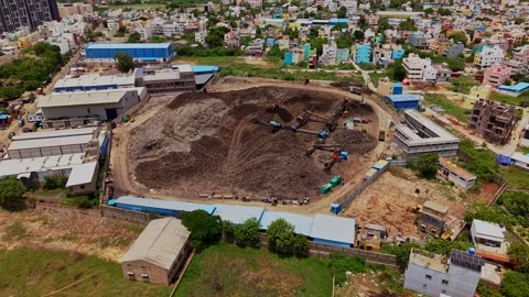 Aerial drone shot of garbage dump yard with heavy machinery in Chennai, India 動画素材 343825607