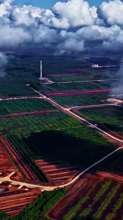 Aerial Drone Shot of Green Fields, Roads, and Industrial Tower Under Cloudy Sky Stock Footage 338422903