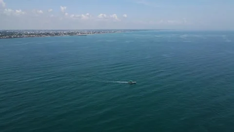 Aerial drone shot highlighting the tiny fisher boat amidst the seemingly endless Stock Footage 297596657