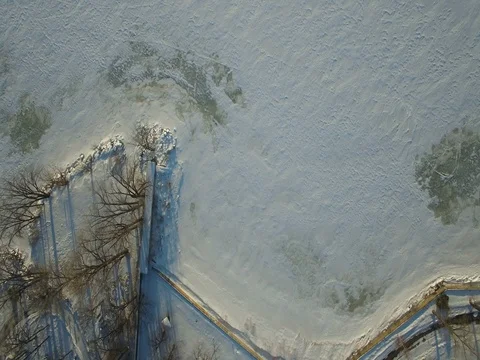 Aerial drone shot looking down at the frozen river by the shore in Montreal Stock Footage 76165995