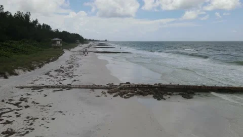 Aerial Drone shot looking down a sparsely populated beach with people enjoyin Stock Footage 138820623