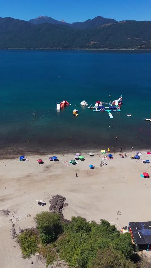 Aerial drone shot moving forward over the beach and inflatable water park g.. Stock Footage 339210496