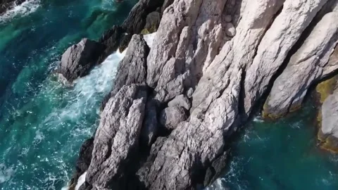 Aerial drone shot of ocean waves rolling and crashing on a rock Stock-Footage 244774480