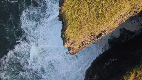 Aerial Drone Shot of Ocean Waves Crashing Against Grassy Cliffs at Loop Head Stock Footage 345685941