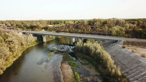 Aerial drone shot of old rusty iron disused railway bridge over the river. Video stock 150362936