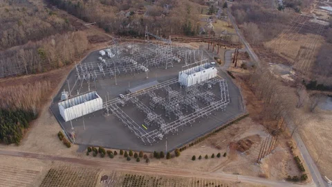 Aerial Drone Shot Orbiting a Large Electrical Substation Next to Farmland Stock Footage 128710236