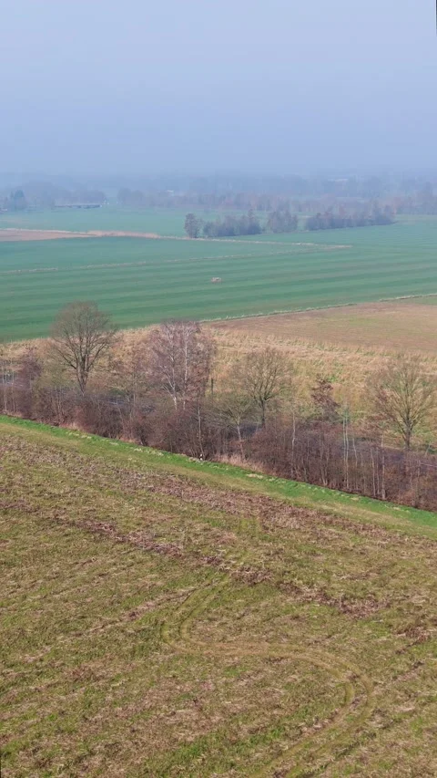 An aerial drone shot overlooking a layered rural landscape in early spring Stock Footage 336406943