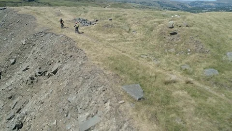 Aerial drone shot passing two mountain bikers on trail Stock Footage 106076471