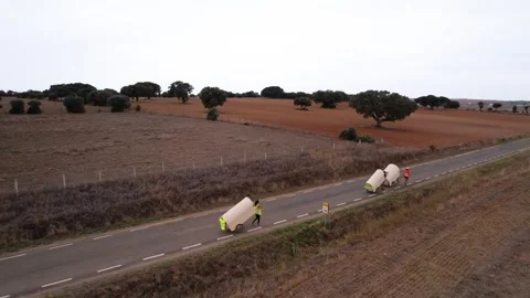 Aerial drone shot of people pulling camping carts on asphalt road amidst ag.. Stock Footage 260389900