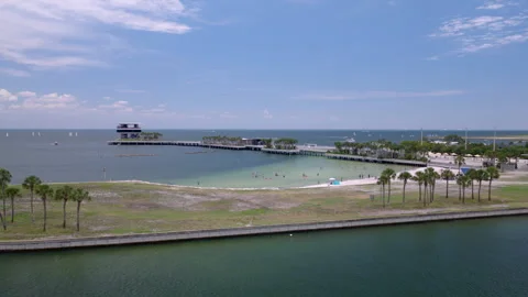 Aerial drone shot pushing toward St Pete Pier beachfront and waterfront park Stock Footage 344295451