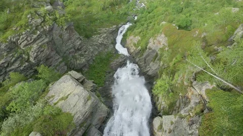 Aerial drone shot of river stream waterfall flowing on green rocky mountain Stock Footage 215876223