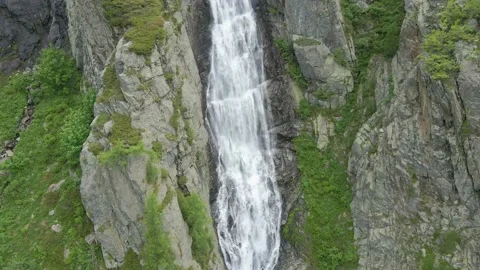 Aerial drone shot of river stream waterfall flowing on green rocky mountain Stock Footage 215876592