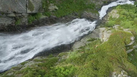 Aerial drone shot of river stream waterfall flowing on green rocky mountain Stock Footage 215877148