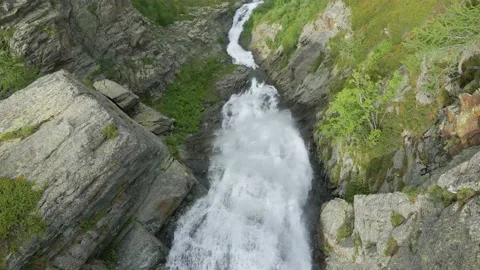 Aerial drone shot of river stream waterfall flowing on green rocky mountain Stock Footage 215877318