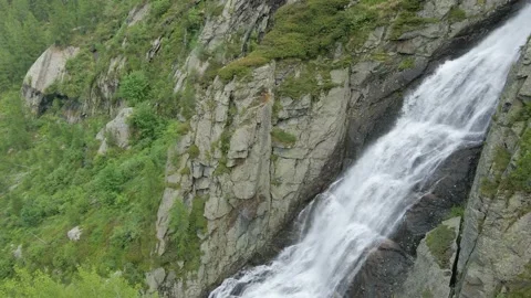 Aerial drone shot of river stream waterfall flowing on green rocky mountain Stock Footage 215877348