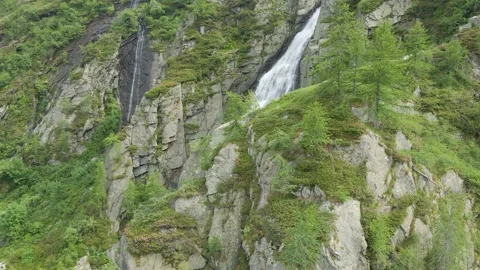 Aerial drone shot of river stream waterfall flowing on green rocky mountain Stock Footage 215877696