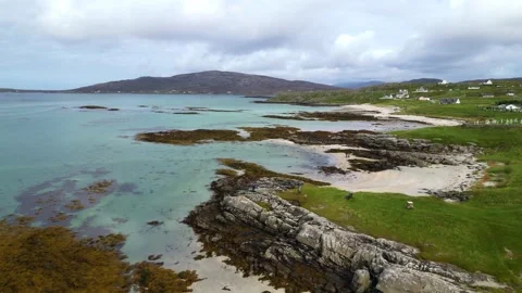 Aerial Drone Shot of Sandy Beach, Rocky Coast, and Village on South Uist Stock Footage 346376053