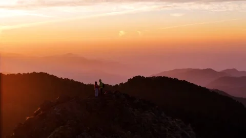 Aerial drone shot showcasing the first light of dawn touching the peaks around Stock Footage 310747924