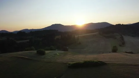 Aerial, drone shot of sunset over meadows and forest under the mountains, Low Stock Footage 146437250
