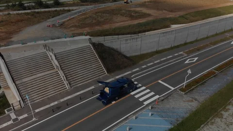 Aerial drone shot, three tuned vans in Fukushima streets, 4K stabilized Stock Footage 107326735
