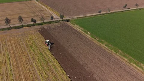 Aerial drone shot of a tractor working on organic farmland. Sustainable Видео 332815557