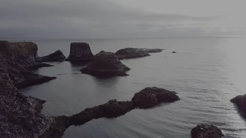 Aerial drone shot travelling into the sea in Iceland, with rocks on the coast. Stock Footage