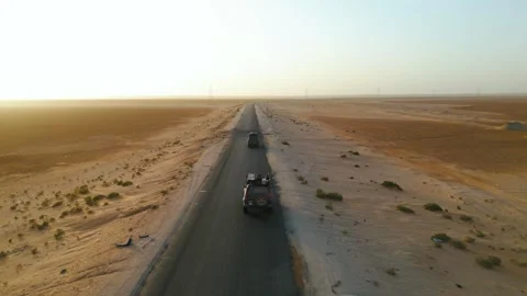Aerial Drone Shot of Two 4x4 Vehicles Driving on Desert Road at Sunrise Stock Footage 341517299