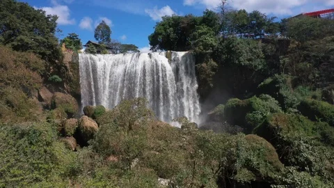 Aerial Drone Shot of WaterfallBehind Tree Branches Vietnam Video stock 124964100