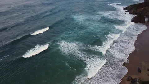 Aerial drone shot of waves breaking at shoreline Stock Footage 261706361