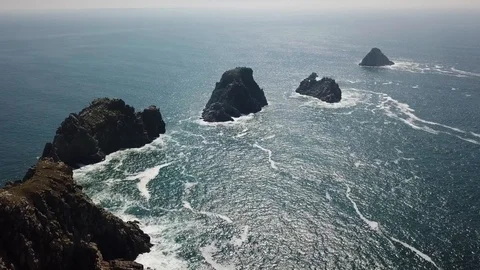 Aerial drone shot. Waves hitting rocks on the beach. Stock Footage 128379838