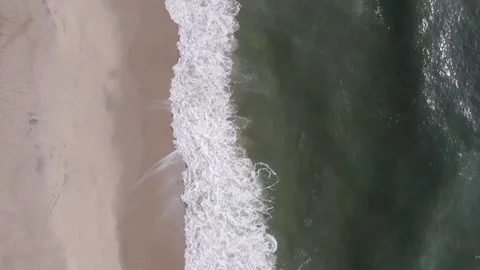 Aerial drone shot of the waves hitting the sand 库存影片 161042049