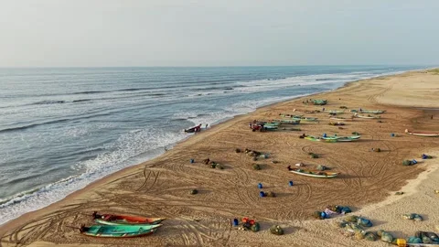 Aerial drone shot of waves rolling onto Chennai beach with fishing boats along Stock Footage 341509055
