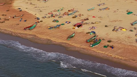 Aerial drone shot of waves rolling onto Chennai beach with fishing boats on Stock Footage 342065114