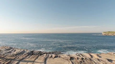 Aerial Drone Side Angle of Athletic Man Running on Cliffs Near Ocean at Sunrise Stock Footage 120773100