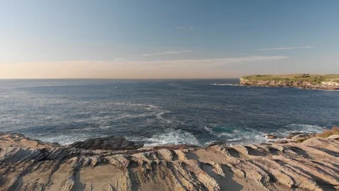 Aerial Drone Side Angle of Athletic Man Running on Cliffs Near Ocean at Sunrise Stock Footage 120773117