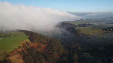 Aerial drone slow flight down valley towards hilltop farm with clouds and mast Video stock 124498854