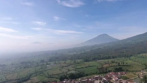 Aerial Drone Slowly Tracking in at Mountains Peaks Above Clouds and Blue Sky Stock Footage 256277330