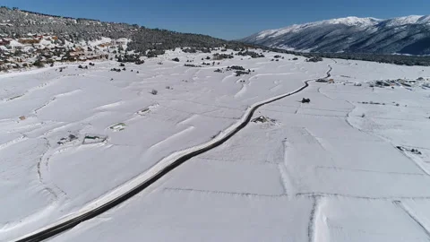 AERIAL DRONE SMOOTH FORWARD IMAGE OF COUNTRY ROAD IN SNOWED WINTER FIELDS Stock Footage 130339431