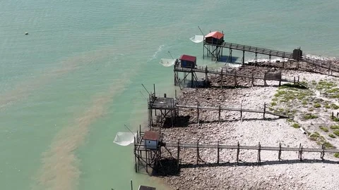 Aerial Drone Speed zoom and circular movement above wooden fishing huts Video stock 316070053