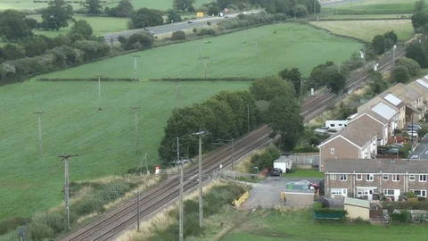Aerial drone static shot train traveling fields and properties Video stock 122584425