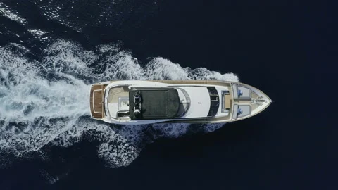 AERIAL DRONE STILL TOP-DOWN LUXURY YACHT SAILING IN BLUE DEEP SEA AND WHITE FOAM Stock Footage 130340443