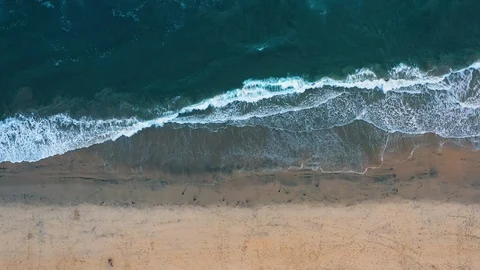 Aerial drone straight down view of ocean waves on sandy beach in resort town Stock-Footage 98951659