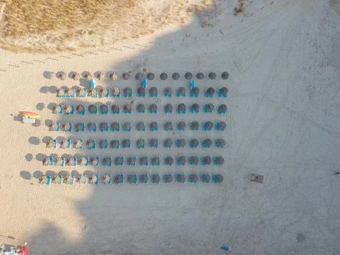 Aerial drone sunbathing sandy beach umberellas sun loungers people sunbathing Stock Photos